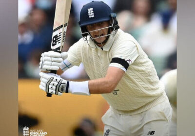 Joe Root, in white shirt and blue cap, in action