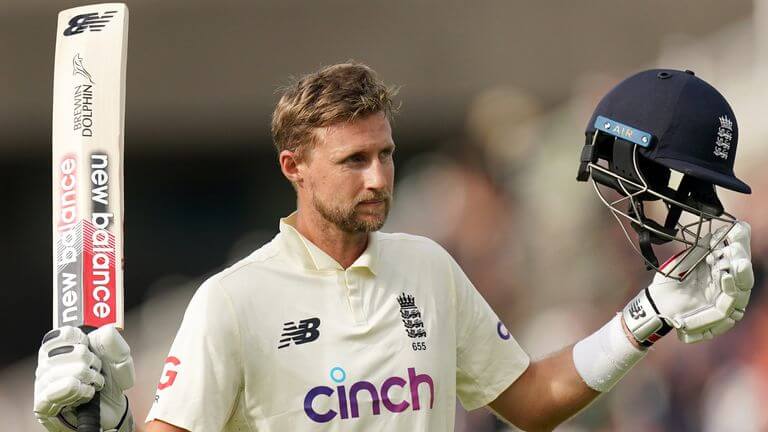 Joe Root, in white polo shirt, acknowledges cheers from the crowd during a match.