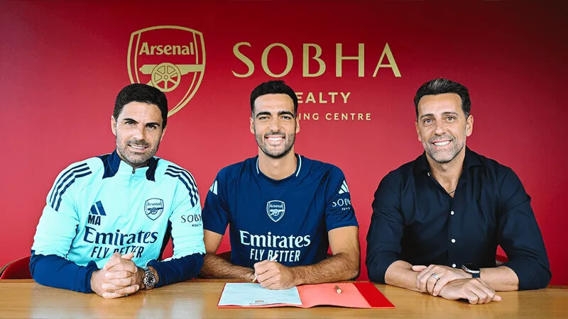 Merino (center) signs the contract with Arsenal manager Mikel Arteta (left) and sporting director Edu (right)