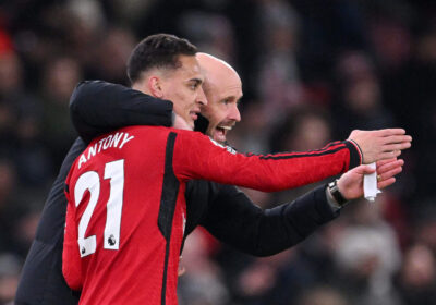 Antony, with jersey No.21 uniform, gets instructions from Erik Ten Hag in a United match. Antony wants to stay with United amid interest from Fenerbahce