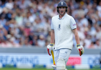 Harry Brook, in white uniform and dark cap, looks on during a match break. Brook has been tapped as England captain, replacing Joe Buttler