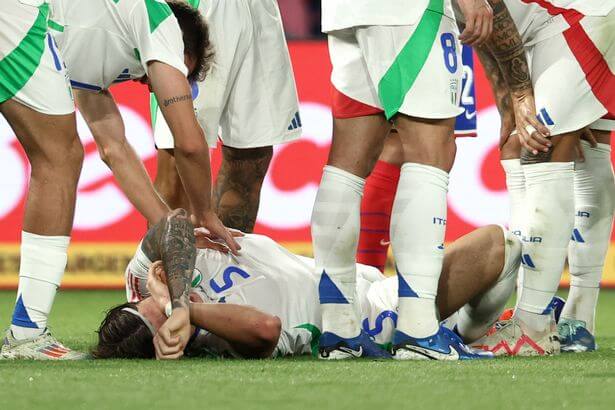 Ricardo Calafiori grimaces in pain after he went down with a leg injury in Italy's match against France. Italy has released Calafiori back to Arsenal.