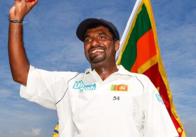 Muttiah Muralitharan, in white uniform, waves to the crowd after a match. Muralitharan doubts if his Test wickets record may be broken