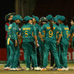 The Pakistan men's cricket team, in green uniforms, take a huddle during a match. The PCB is set to conduct stringent fitness tests this month.