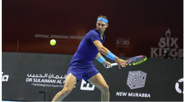 Rafael Nadal, in blue uniform, returns a shot in his match against Carlos Alcaraz. Nadal says Six Kings Slam 'an opportunity to be better' despite the loss to Alcaraz.