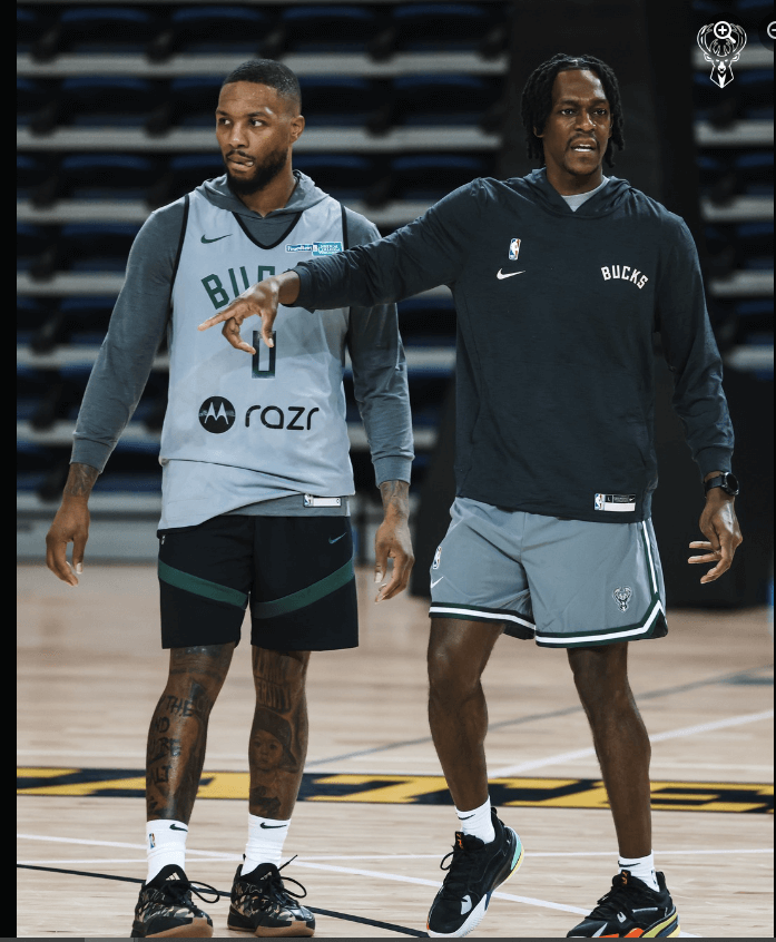 Rajon Rondo, in dark green Bucks hoodie, calls out a play with Bucks pointguard Damian Lillard, left, at training camp. The top 10 possible Rajon Rondo traits grew after Rondo was tapped as guest coach at the Bucks' training camp.