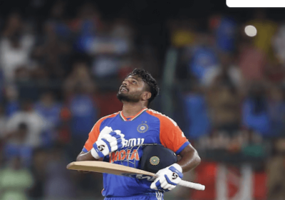 Sanju Samson, in blue and orange uniform, looks in the sky during a lull in India's Test match against Bangladesh. Samson was honored in India for topping Rohit Sharma's T20I record.