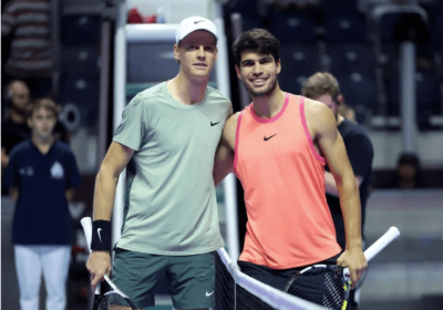 Jannik Sinner, in light green shirt, and Carlos Alcaraz, in orange shirt, pose for photographers in a file photo. Sinner tops Alcaraz for Six Kings Slam title.