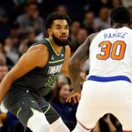 Karl Anthony Towns, in green Timberwolves jersey No. 32, guards New York Knicks' Julius Randle in a regular season game. Towns bids the Wolves farewell after the Knicks made the trade official