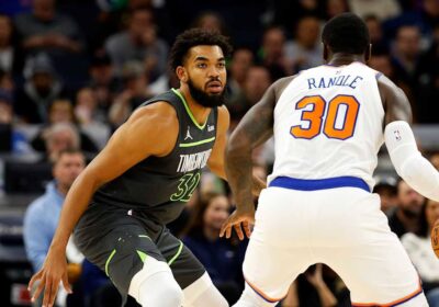 Karl Anthony Towns, in green Timberwolves jersey No. 32, guards New York Knicks' Julius Randle in a regular season game. Towns bids the Wolves farewell after the Knicks made the trade official