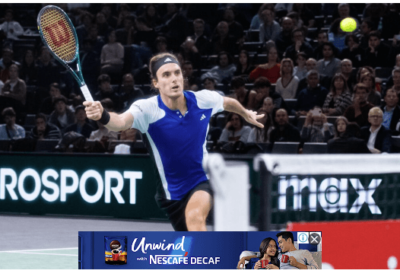 Greece's Stefanos Tsitsipas, in blue and white shirt, tries to return the ball at the 2024 Paris Masters on Monday. Tsitsipas beats Baena in Paris Masters opener