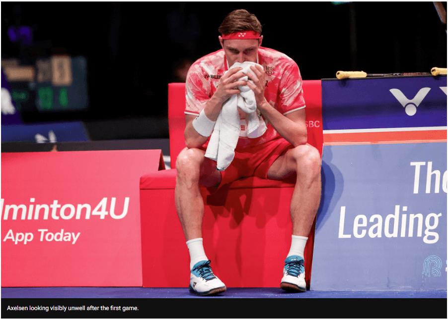 Denmark's VIktor Axelsen, in red uniform, sits helplessly in a lull during his match at the 2024 Denmark Open. Axelsen forced to quit at Denmark Open due to sickness.