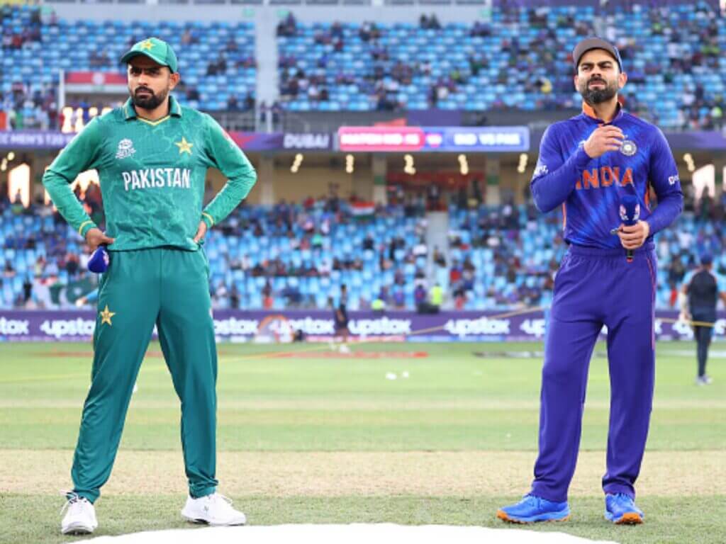 Pakistan's babar Azam (left, in green uniform), and India's Virat Kohli (right, in blue) stand close to each other during a break in a match. Azam surges to 2nd in T20I run-scorers' list after surpassing Kohli