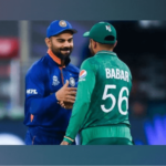 India's Virat Kohli (left, in blue), shakes hands with Pakistan's Babar Azam (right, in green), during a break in a match. Azam surges to 2nd in T20I run-scorers' list after surpassing Kohli