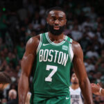 Celtics star Jaylen Brown, in Celtics green jersey No.7, walks on the floor at a recent game. Brown, Nike trade barbs over 'childish' Giannis reference