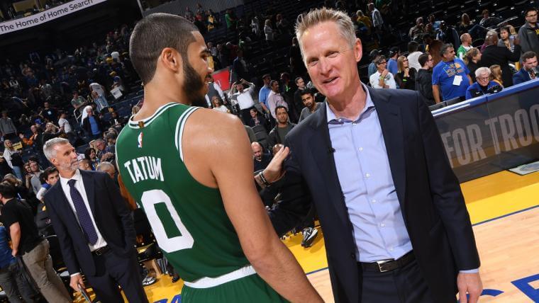 Coach Steve Kerr, right, in black suit, talks to Boston star Jayson Tatum (left), in Celtics green jersey, on Wednesday. Kerr gets booed by Celtics fans but Warriors win in Boston