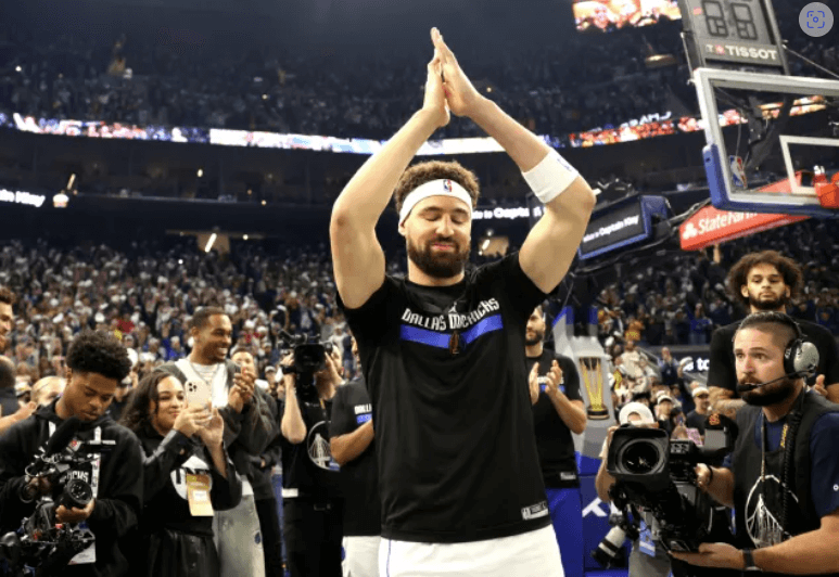 Klay Thompson, center in Dallas Mavericks shirt, raises his arms to acknowledge the cheers of the crowd on Tuesday. Thompson gets 'Captain Klay' tribute in Chase Center return