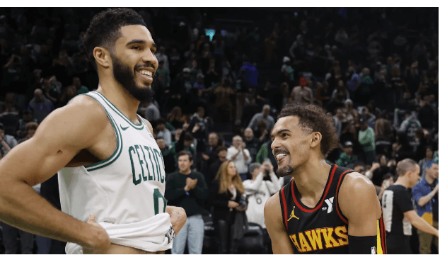 Boston Celtics' forward Jayson Tatum (left) and Atlanta Hawks guard Trae Young (right) share a light moment in file photo. NBA fines Hawks for violating player participation policy on Young