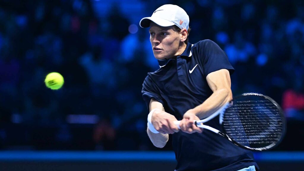 Italy's Jannik Sinner, in dark blue shirt, returns a shot in his match in Turin on Thursday. Sinner stays undefeated in ATP Finals after beating Medvedev