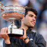 Spain's Carlos Alcaraz (in black jacket) clutches one of his trophies he won in 2024. Alcaraz has to learn 'how to say no' to manage schedule, says Roddick