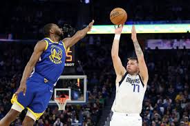 Dallas guard Luka Doncic (right, 77) shoots over an unidentified Golden State defender in the teams' game on Sunday. Mavs top Dubs despite Warriors' 3s record