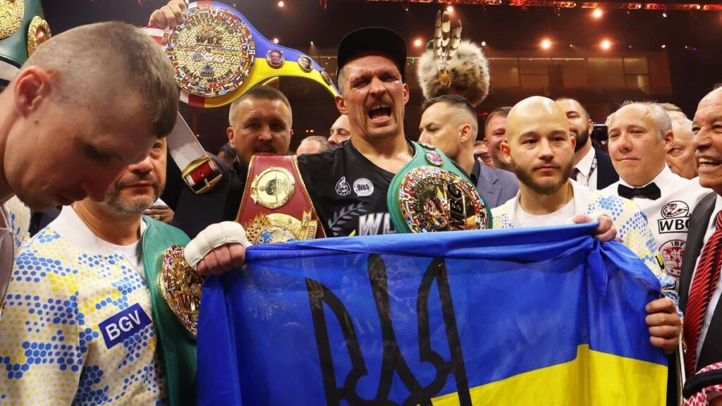 Ukraine's Oleksandr Usy, middle carrying belt in black shirt, beams with pride along with his team and supporters in his fight against Tyson Fury on Saturday. Usyk seeks Dubois-Parker winner for undisputed heavyweight title