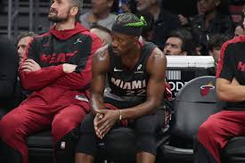 Miami forward Jimmy Butler (right) sits on the bench in file photo. Butler still wants to be traded as 7-game suspension nears end