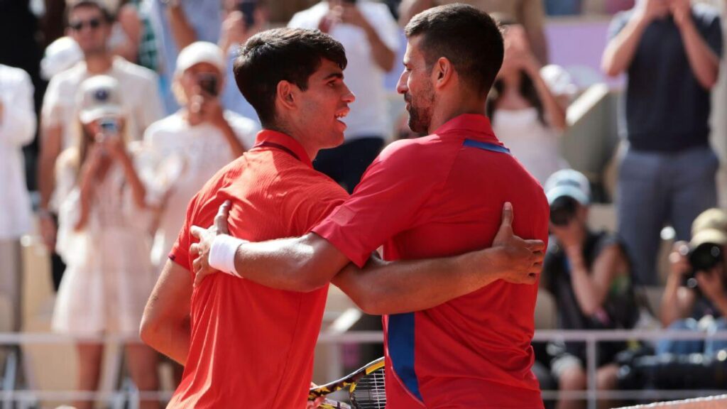 Spain's Carlos Alcaraz (left) and Serbia's Novak Djoovic (right) share a light embrace and a conversation after a match in file photo. Djokovic, Alcaraz in same side of Australian Open draw