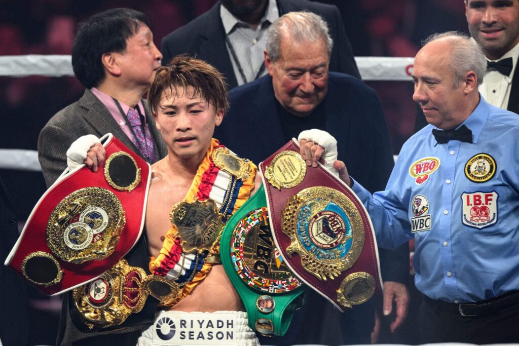 Japan's Naoya Inoue (second from left) holds all his title belts after a successful title defense in Tokyo on Friday. Top Rank promoter Bob Arum (middle) joined Inoue at trhe ring. Inoue set for Vegas fight 