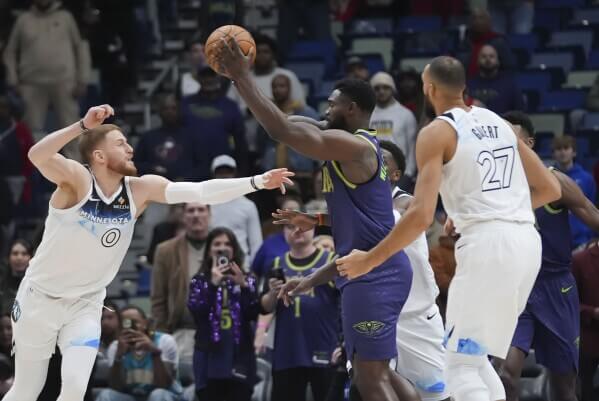 Zion Williamson (1, center) is double-teamed by Donte Divincenzo (left) and Rudy Gobert (27) of Minnesota in their game on Tuesday. Williamson returns after 27-game absence but Pelicans lose