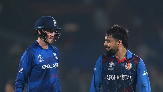 A player from England (in blue) nd Afhanistan (yellow) share a light moment in the pitch during their match on Monday. Afghanistan vs England match set at Champions Trophy