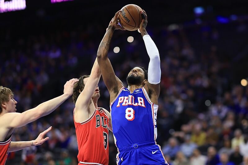 Philadelphia 76ers forward Paul George (8m right) jumps for the ball against Chicago Bulls guard Josh Giddey (3, left) in their match on Monday. Chicago Bulls guard Josh Giddey (left, 3), drives for a layup against Philadelphia 76ers' forward Kelly Oubre(right) during their match on Monday. 76ers vs Bulls marks another missed game for Embiid