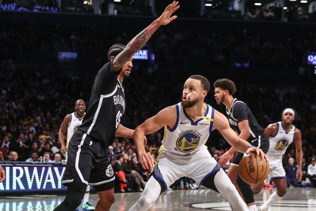 Golden State guard Stephen Curry (right) dribbles against Brooklyn forwqard Keon Johnson (left) in their game on Thursday. Nets vs Warriors showed Curry drop 40 as Dubs win