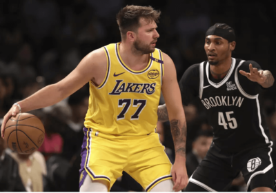 Lakers guard Luks Doncic (77, left) posts up against Brooklyn forward Keon Johnson (45, right) in their teams' game on Monday. Nets vs Lakers game has Brooklyn on top as James sits out