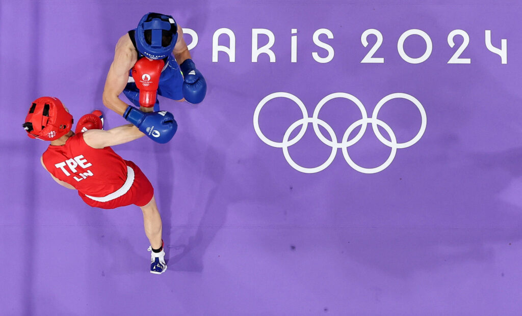 Two boxers slug it out amid the Paris Olympuics 2024 logo in the background in file phto. IOC president Thomas Bach speaks at a news conference in file photo. IOC backs boxing inclusion in LA 2028 Games amid past disputes