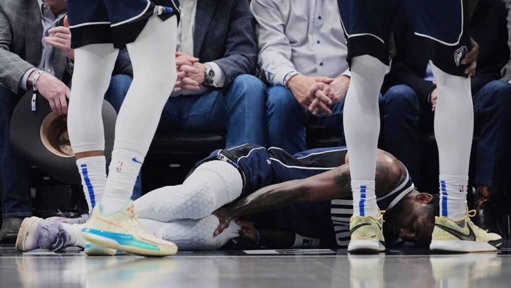 Dallas guard Kyrie Ierving writhes in pain after he had a torn ACL on his left knee on Monday. Irving injury rules him out