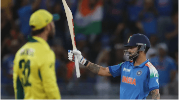 India veteran Virat Kophli (right) sizes up his bat as an unidentified Australia player (left) looks on in theior match on Tuesday. India reaches Champions Trophy 2025 final after beating Australia