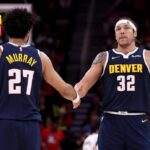 Denver's Jamal Murray (left, 27) and Aaron Gordon (32, right) exchange high-fives in their game against the Houston Rockets on Sunday. Rockets vs Nuggets saw Murray drop 39 as Jokic-less Denver wins