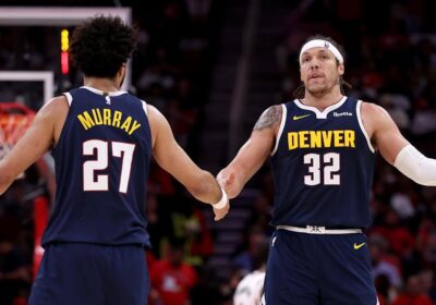 Denver's Jamal Murray (left, 27) and Aaron Gordon (32, right) exchange high-fives in their game against the Houston Rockets on Sunday. Rockets vs Nuggets saw Murray drop 39 as Jokic-less Denver wins