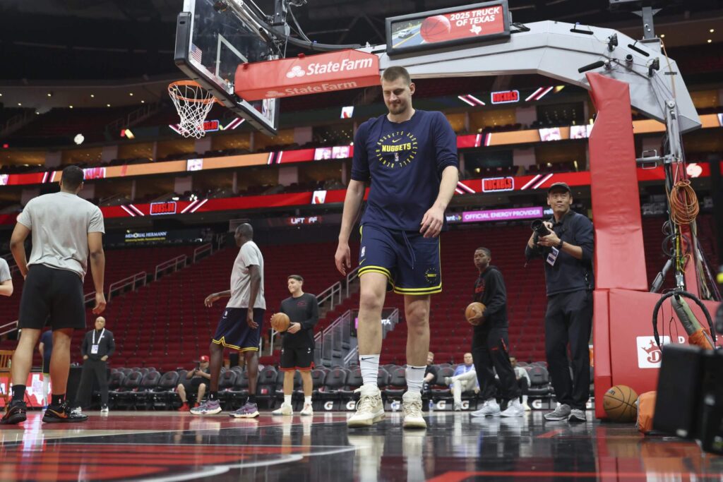 Denver Nuggets center Nikola Jokic, (middle) walks away from players going through warmups in Houston on Sunday. Rockets vs Nuggets saw Murray drop 39 as Jokic-less Denver wins