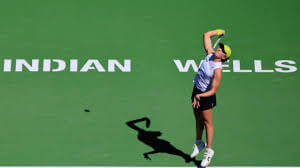 Poland's Iga Swiatek is about hit a shot in her match on Sunday. Greece's Stefanos Tsitsipas pumps his fist to celebrate a point in his match on Sunday. Tsitsipas advances at Indian Wells