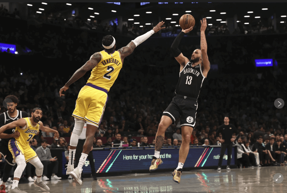 Brooklyn Nets' Tyrese martin (13, right) shoots over Lakers' center Jared vanderbilt (2, kleft)  in their teams' game on Monday. Nets vs Lakers game has Brooklyn on top as James sits out