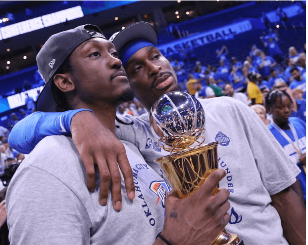 OKC forward Jalen Williams (left) and guard Shai Gilgeous-Alexander (right) pose for photographers with SGA's Western Conference Finals MVP after Game 5 of their series against the Minnesota Timberwolves on Wednesday. Thunder vs Wolves has OKC set to 'buckle up' for NBA Finals 