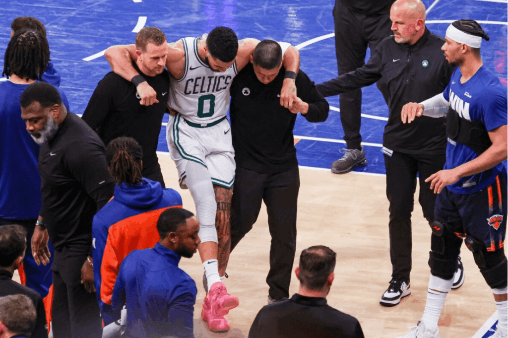Boston forward Jayspn Tatum (0, middle) is carried off by trainers after he injured his right leg in the final minutes of Game 4 of their first-round series against the New York Knicks on Monday. Knicks vs Celtics shows New York get 3-1 lead; Tatum injured